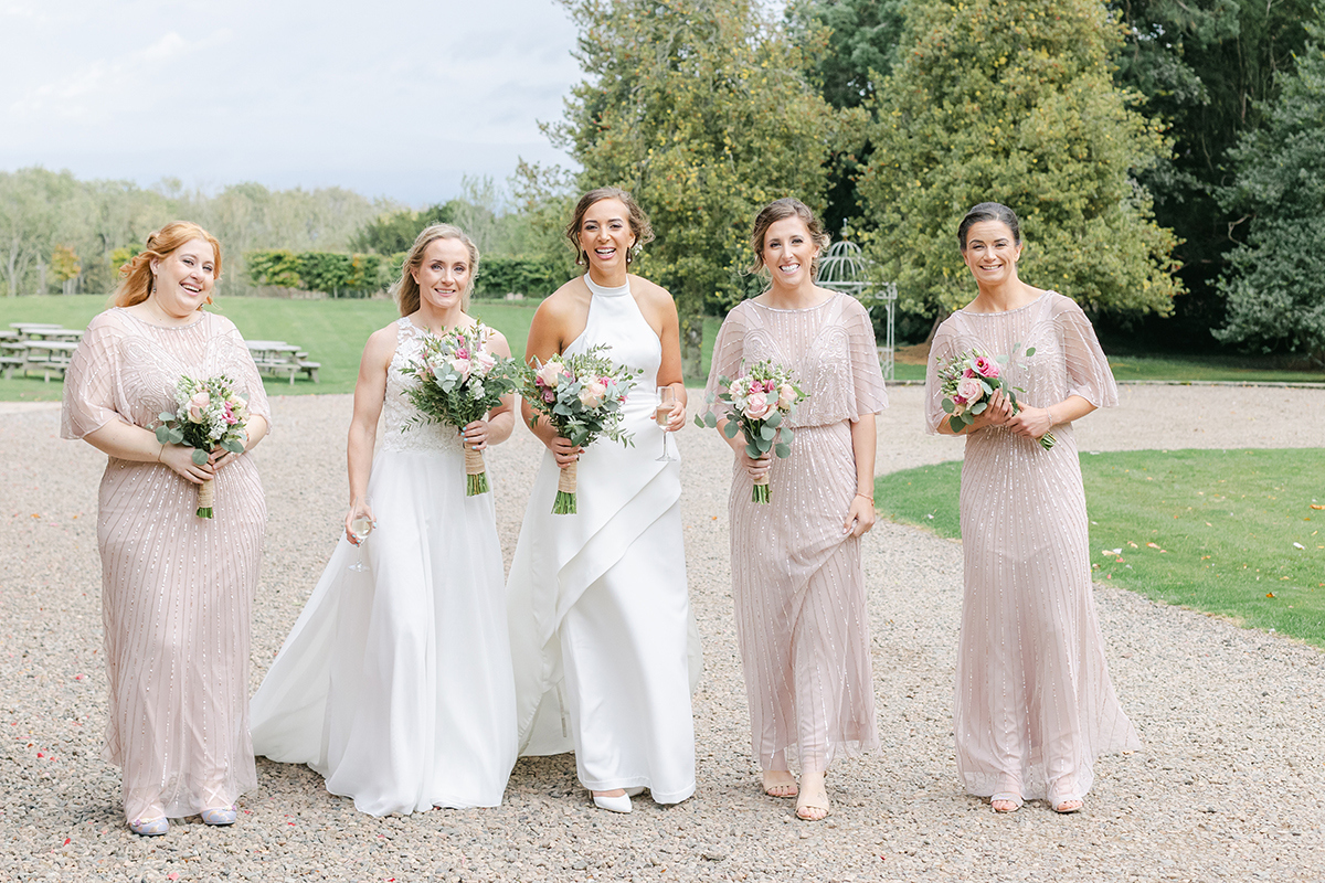 two brides walking with bridesmaids