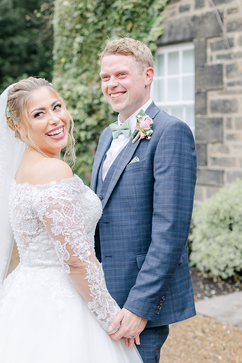 bride and groom laughing at something behind them