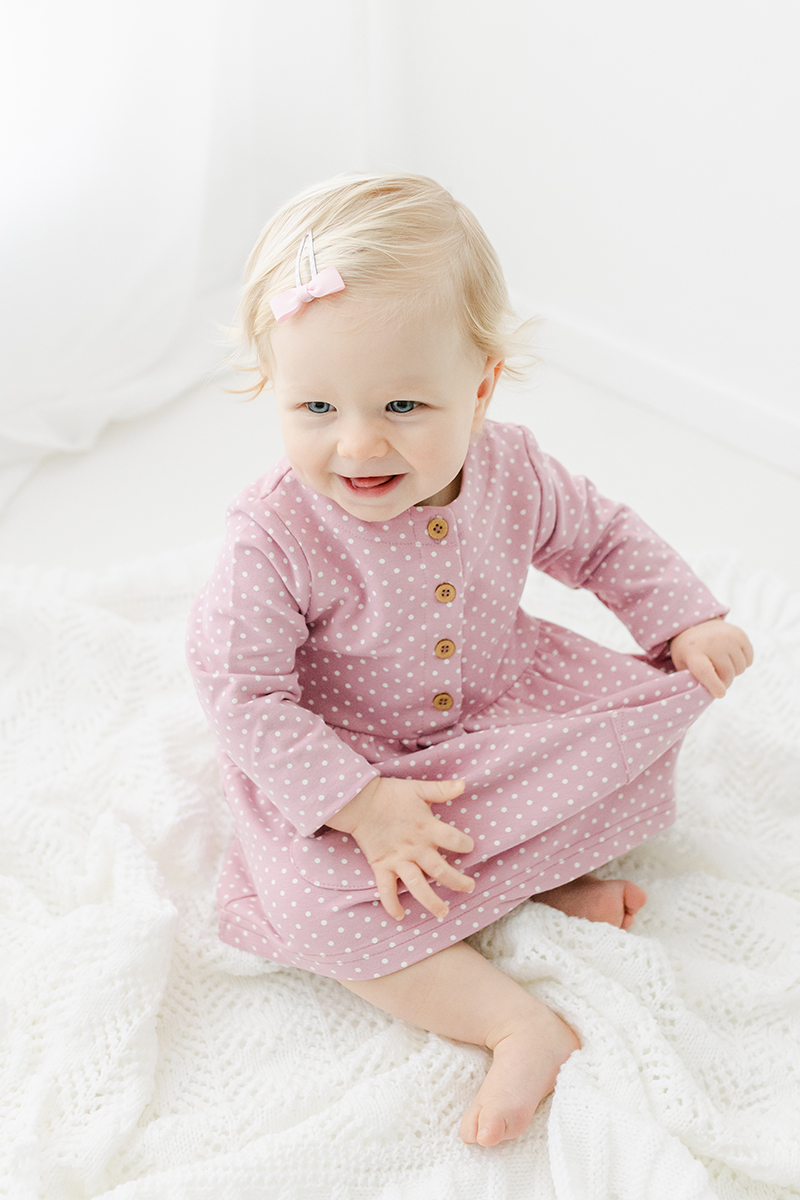 little toddler in pink in photography studio smiling