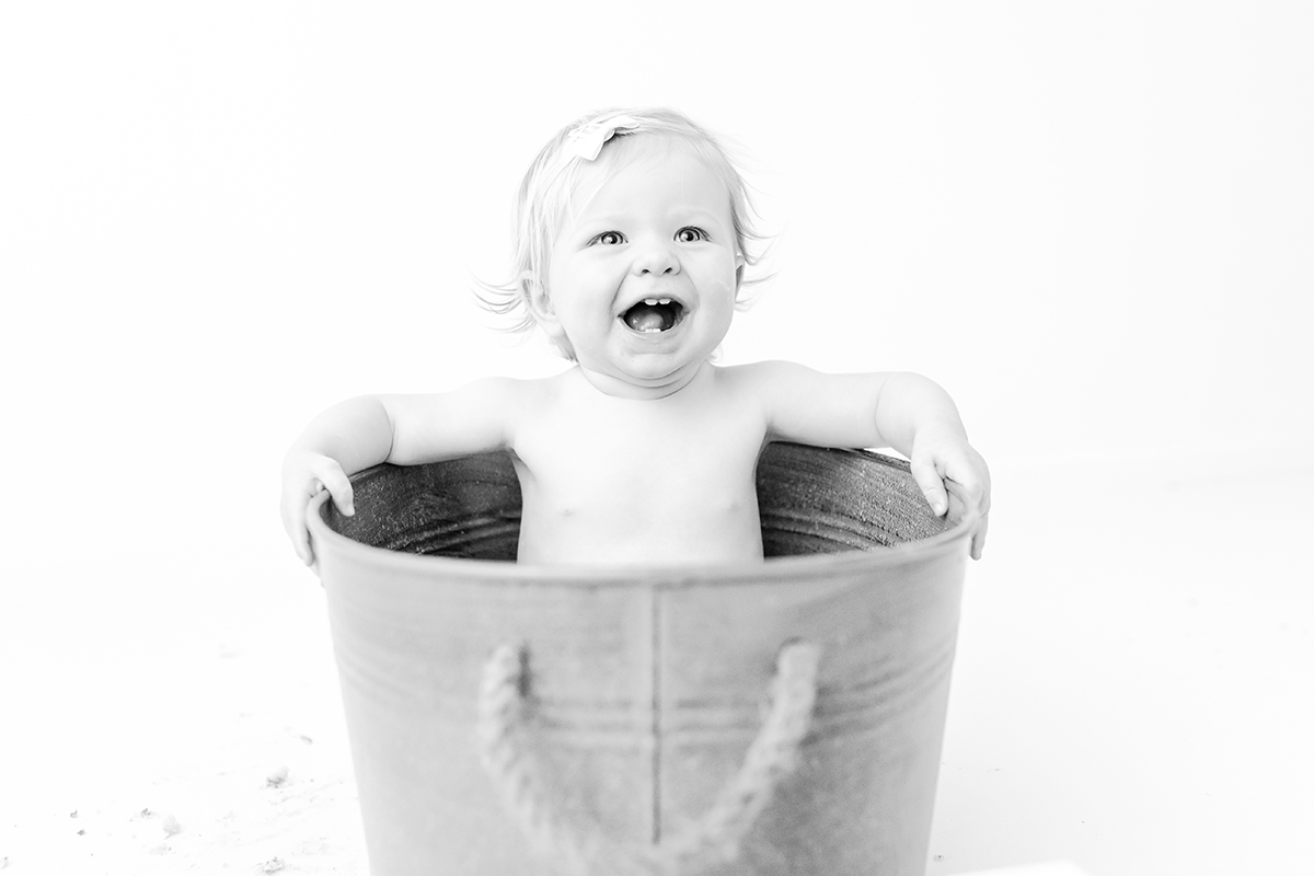 little girl in tin bath tub laughing black and white