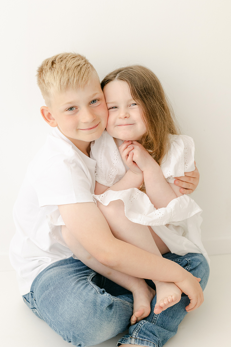 young brother and sister hugging for photo