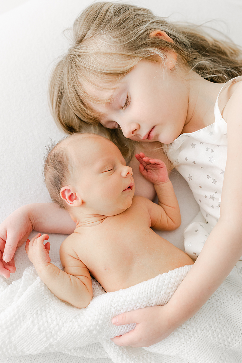 big sister and baby brother asleep together