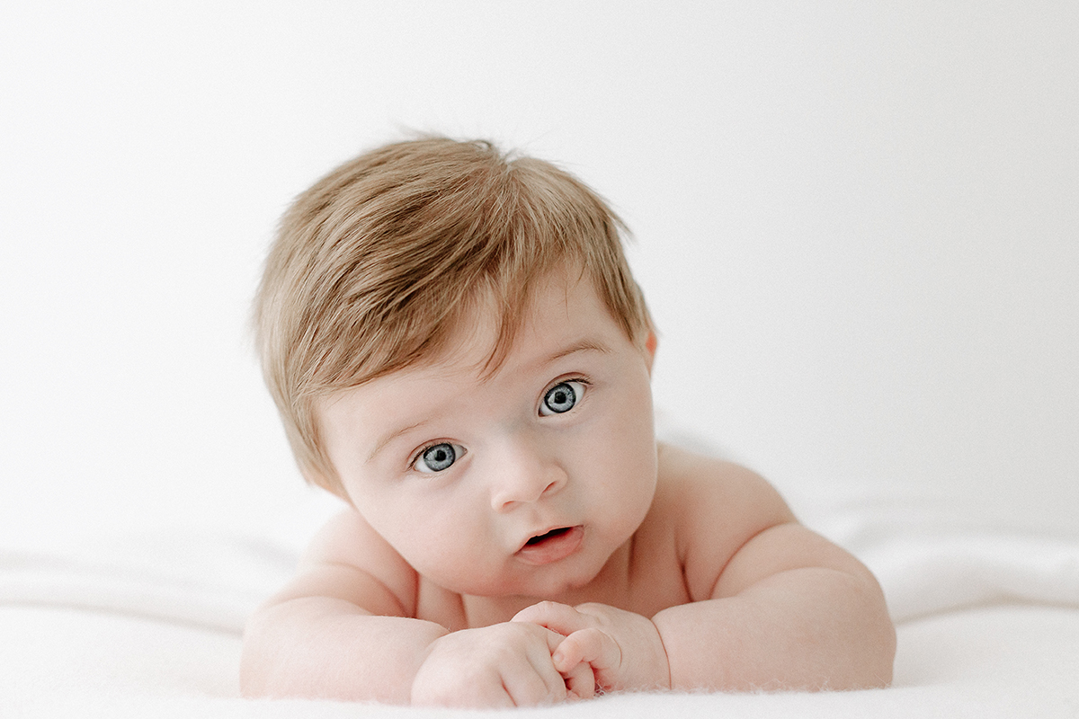 baby boy lying on from looking into camera