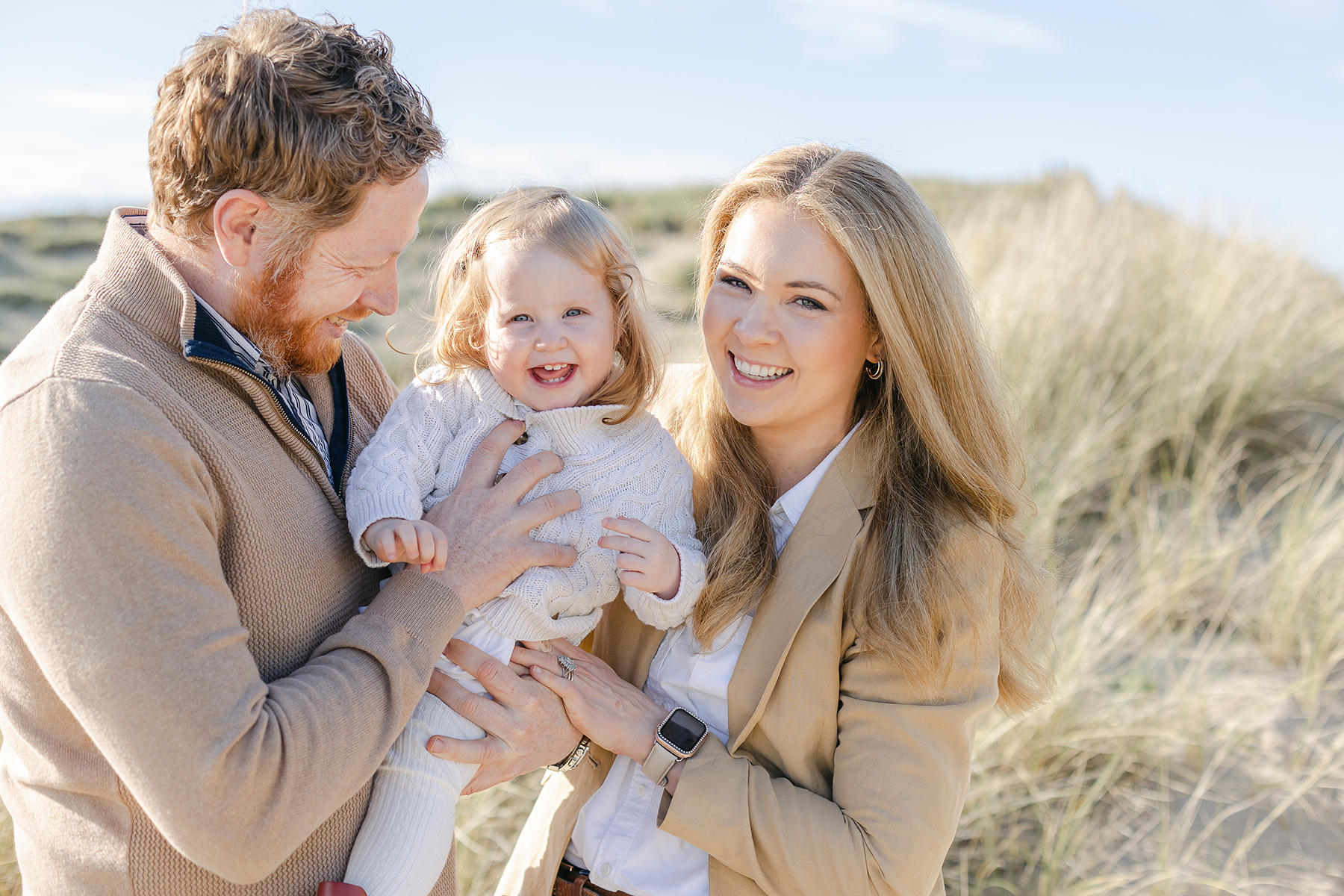 family photo shoot mum and dad laughing with daughter