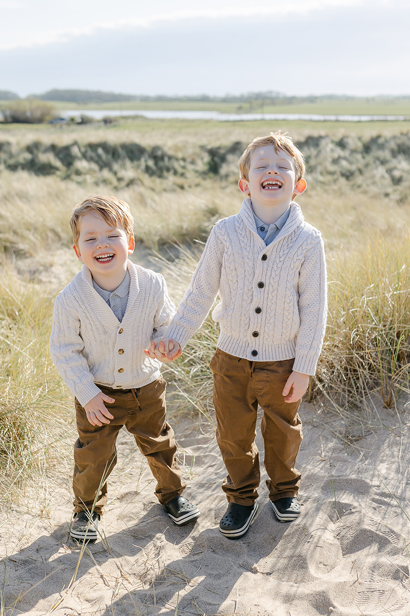 young brothers laughing at camera in dunes