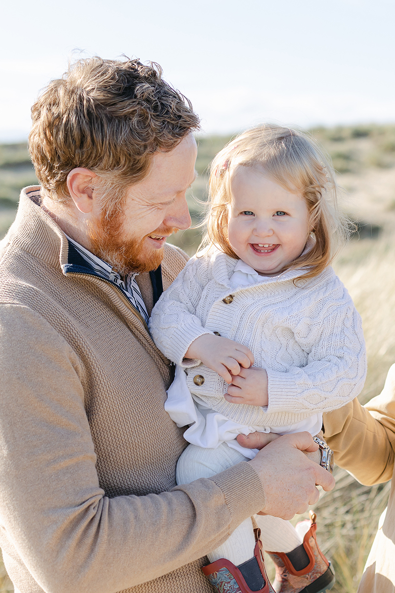 dad smiling at daughter in dunes