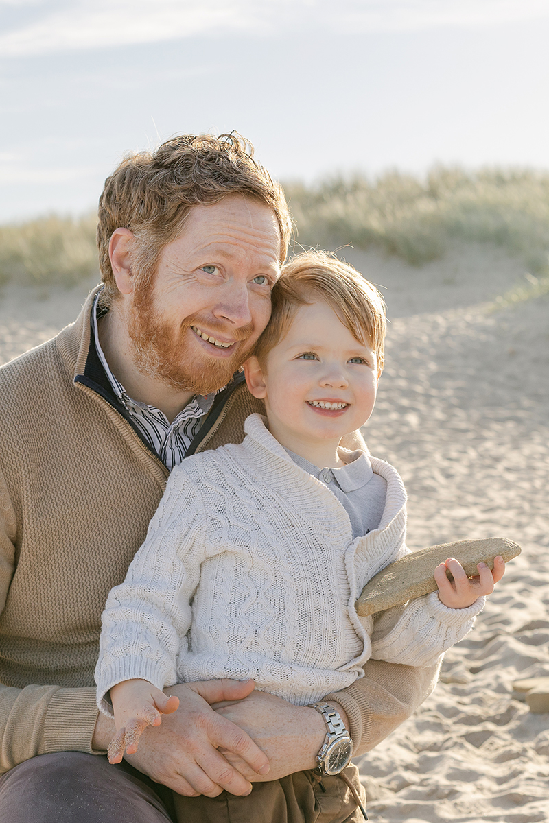 dad and son smiling on the beach