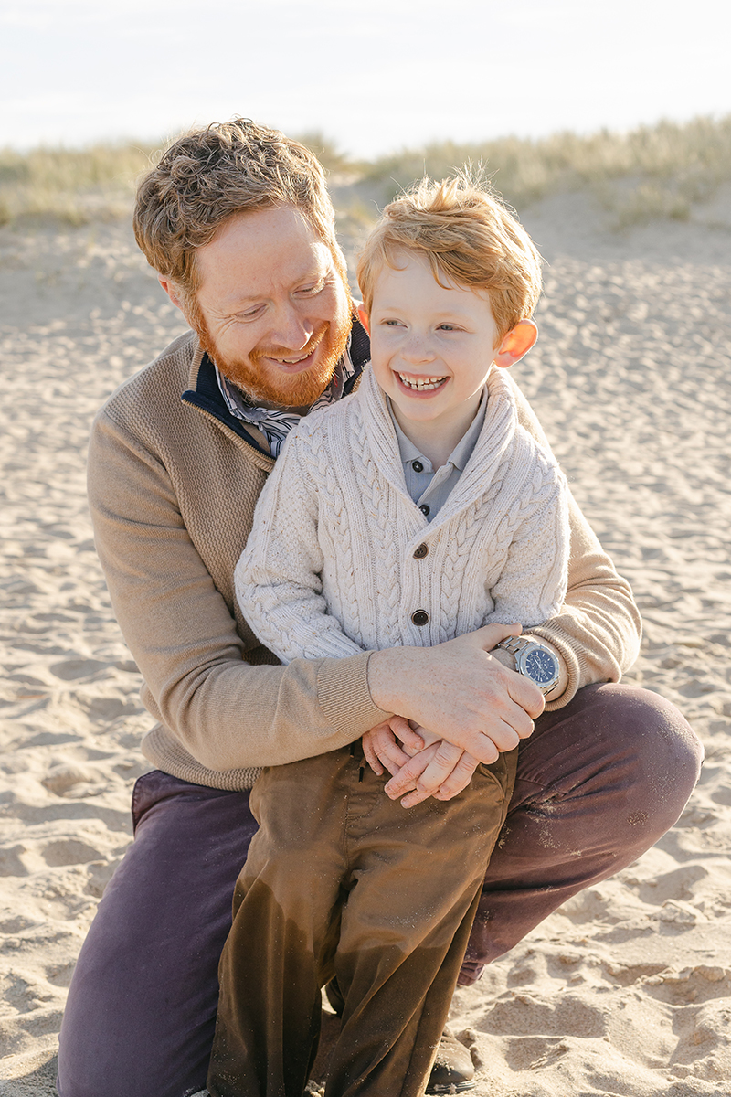 Dad and son hugging on beach