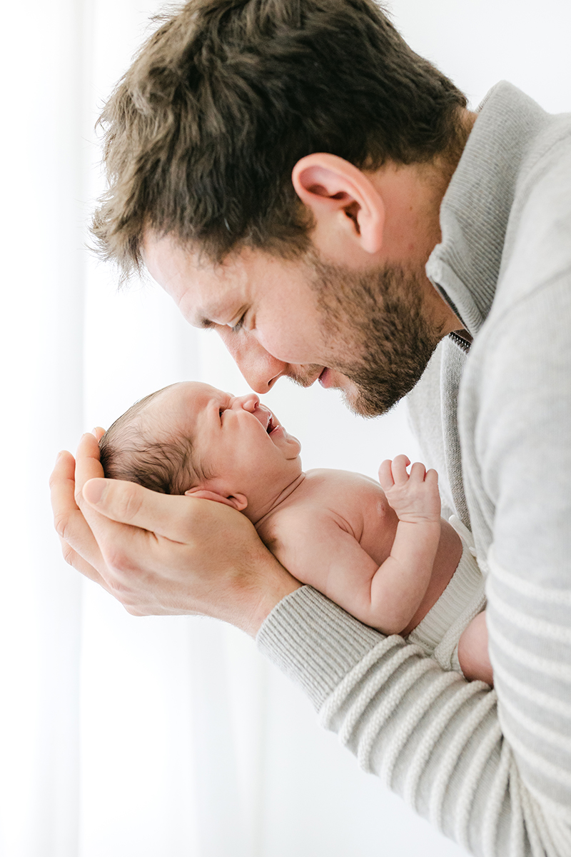 dad touching noses with newborn