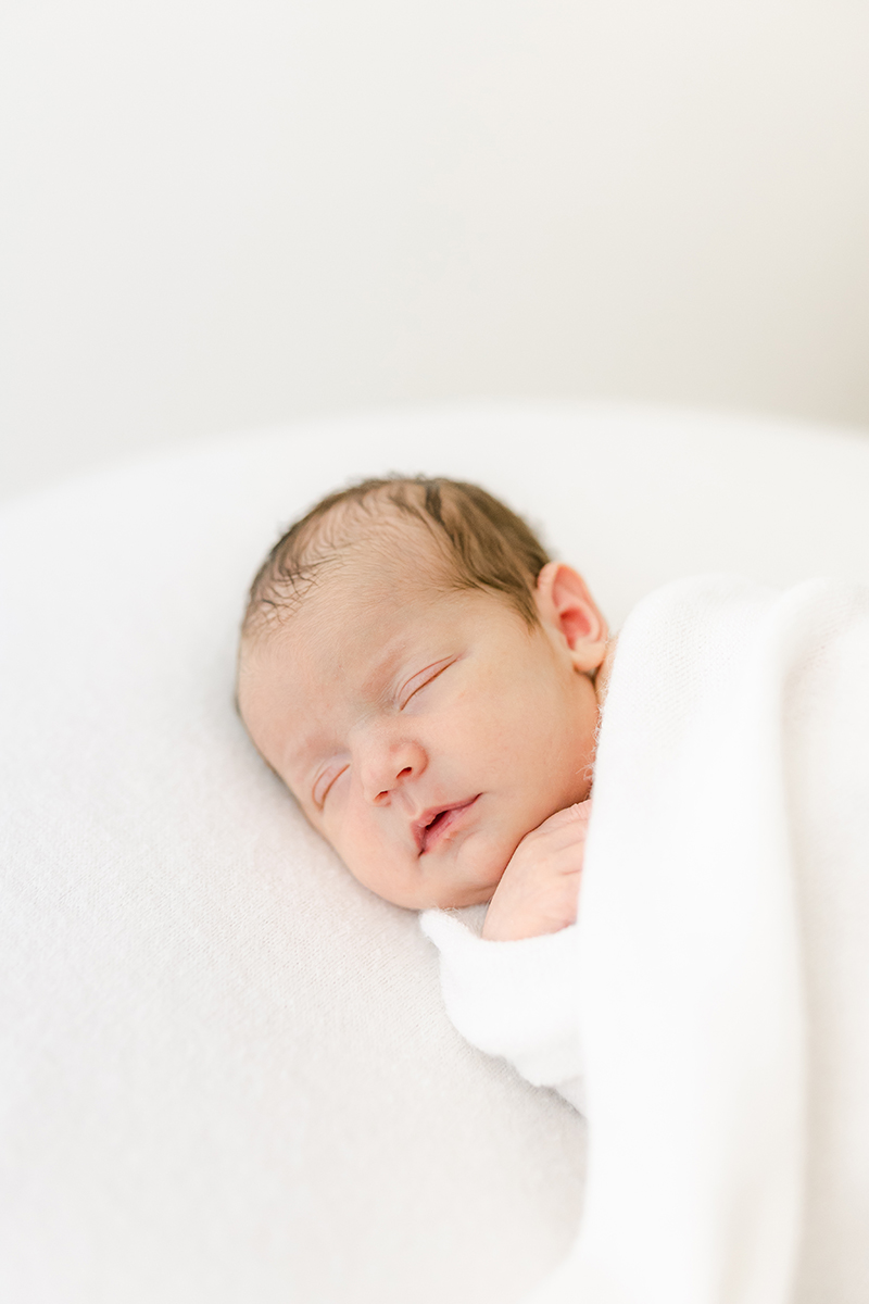 newborn wrapped in white for newborn photoshoot