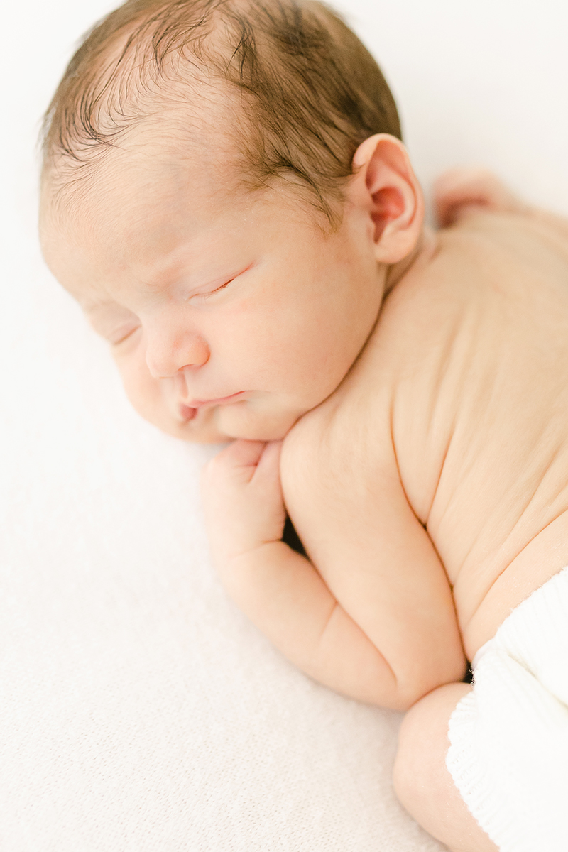 newborn asleep on front showing baby wrinkles