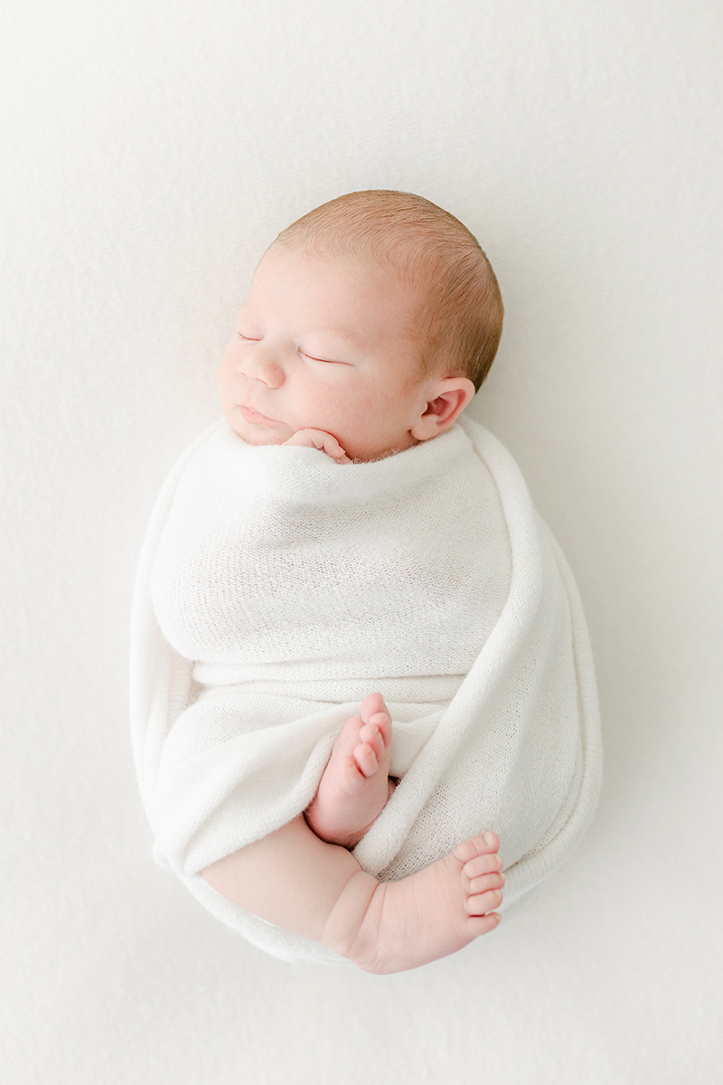 newborn wrapped in a ball alseep