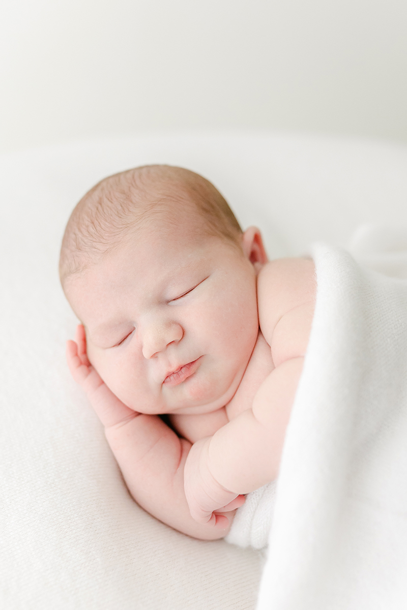 newborn asleep on side showing baby rolls