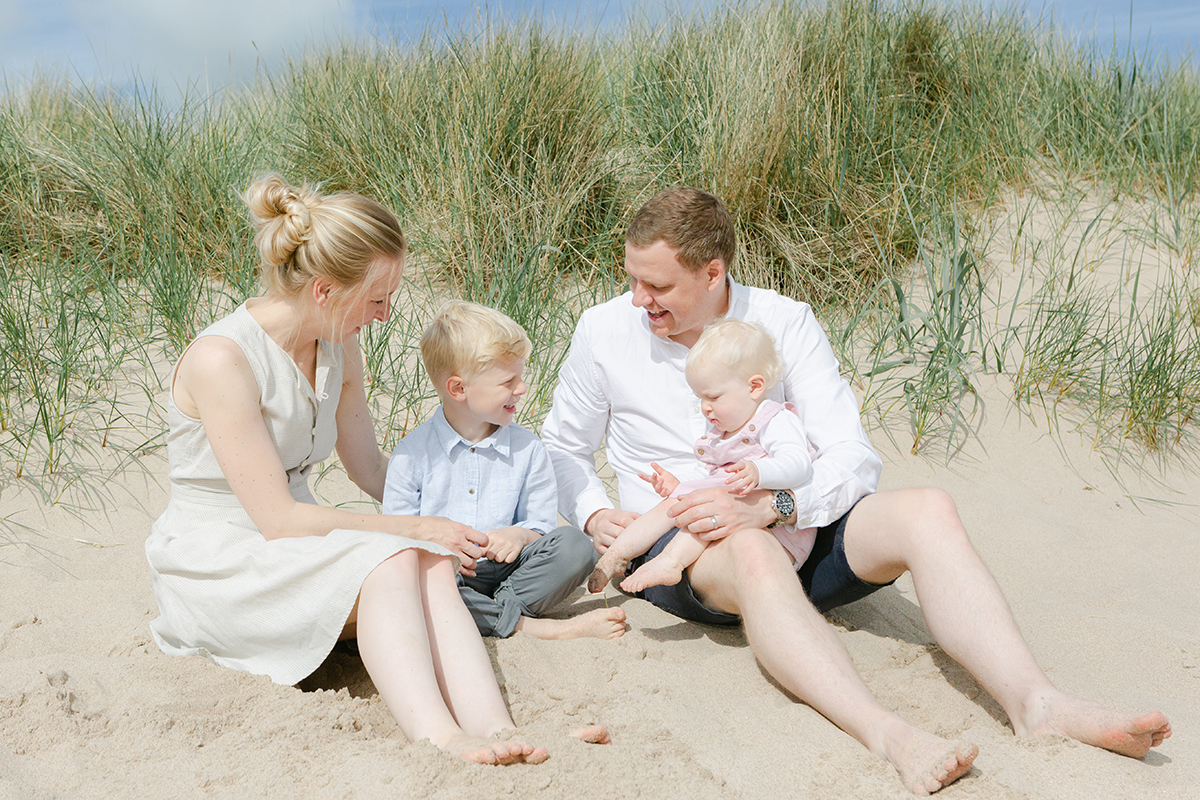 family of four on beach for family photoshoot