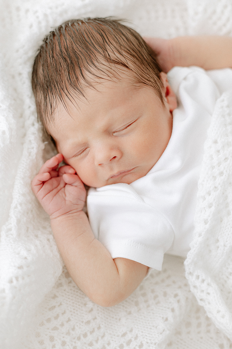 little baby asleep in white blanket