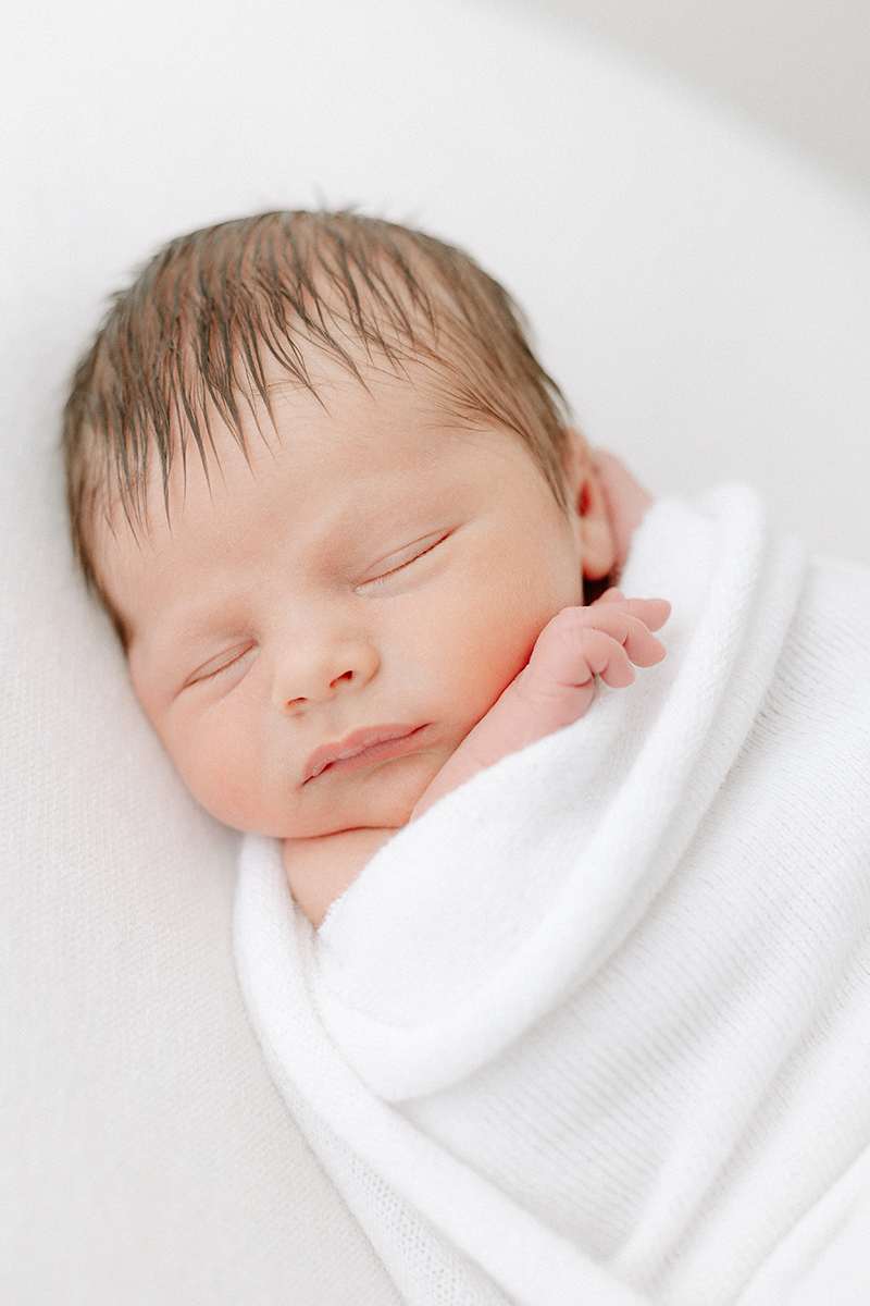 little baby asleep in white blanket