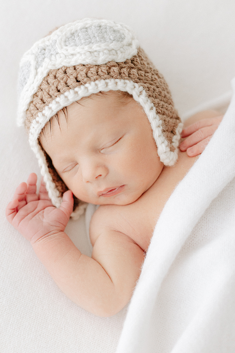 newborn baby asleep with crocheted flying hat