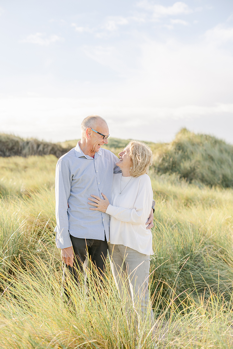 grandparents smiling at each other in dunes