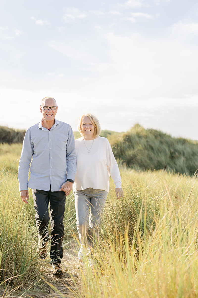 grandparents walking through dunes for family photo