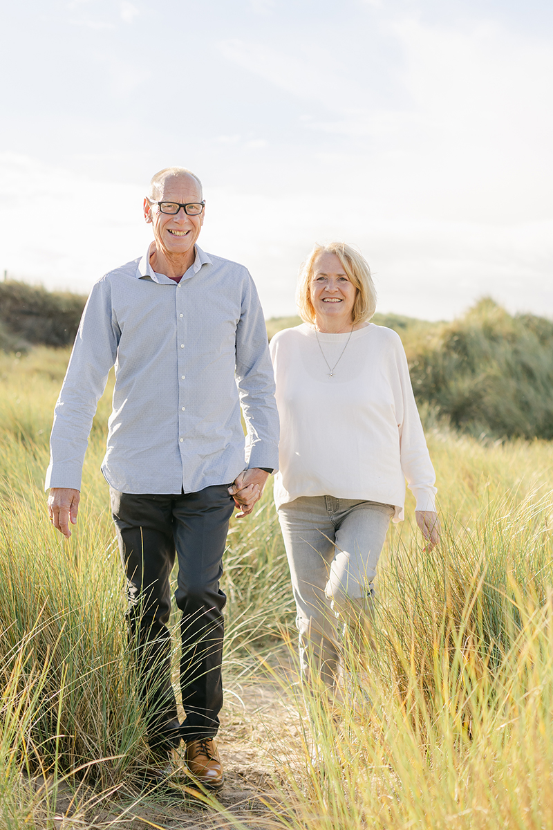 married couple walking through dunes