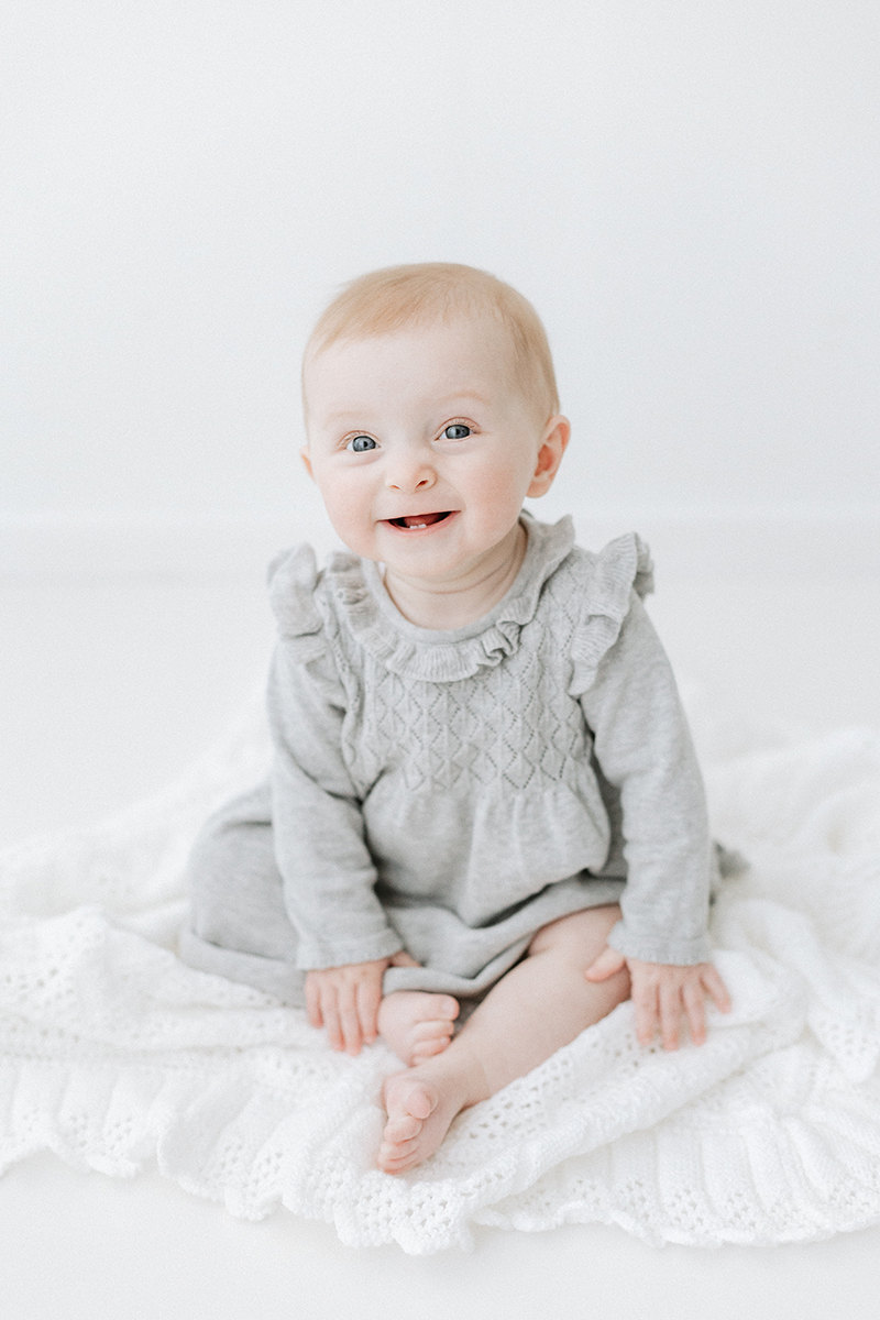 baby sitting up and smiling at camera for sitter photo session