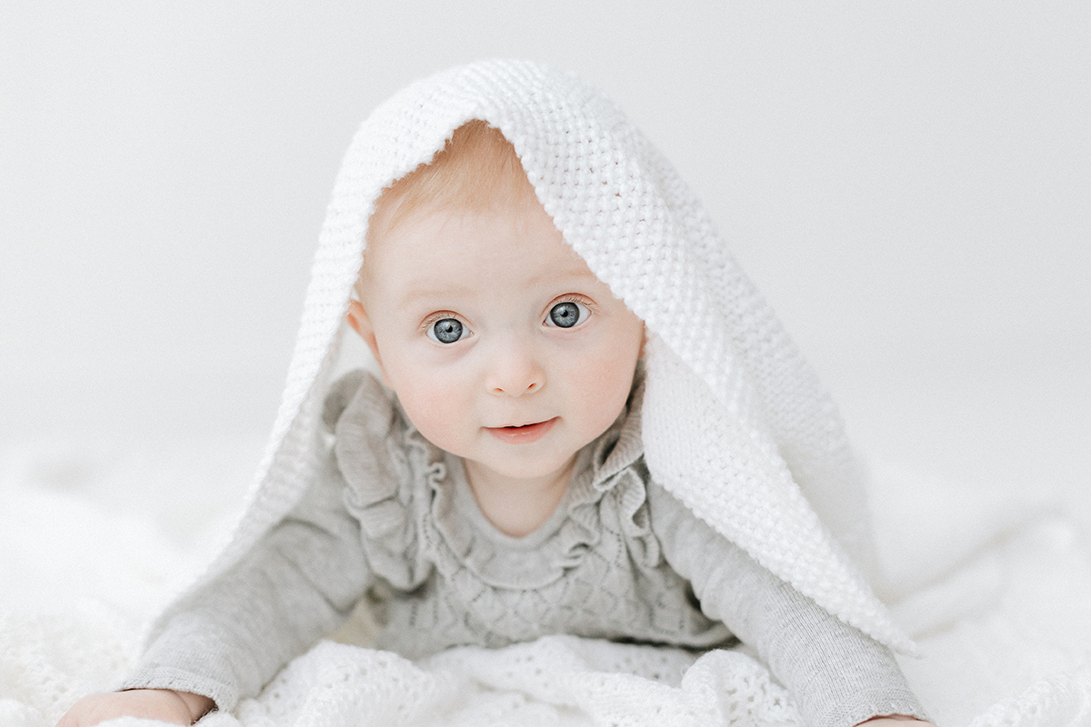 baby hiding under blanket