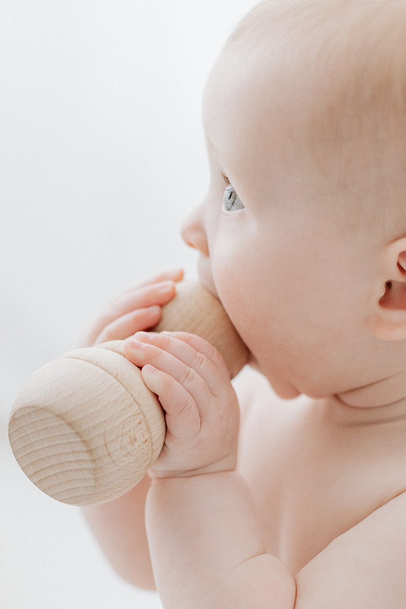 closeup of baby eye while chewing wooden toy